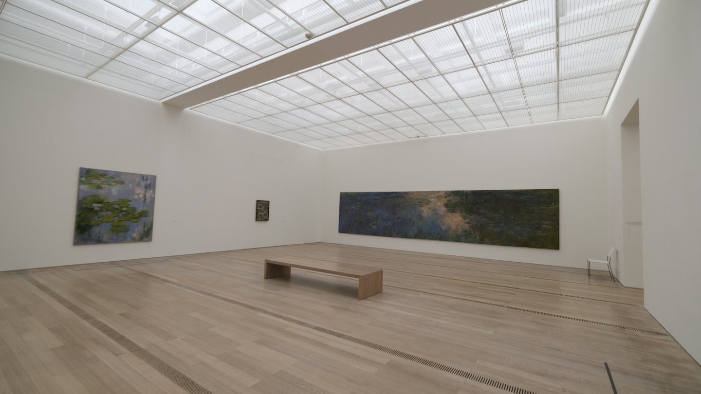 Galleria d'arte moderna con pareti bianche e dipinti esposti.